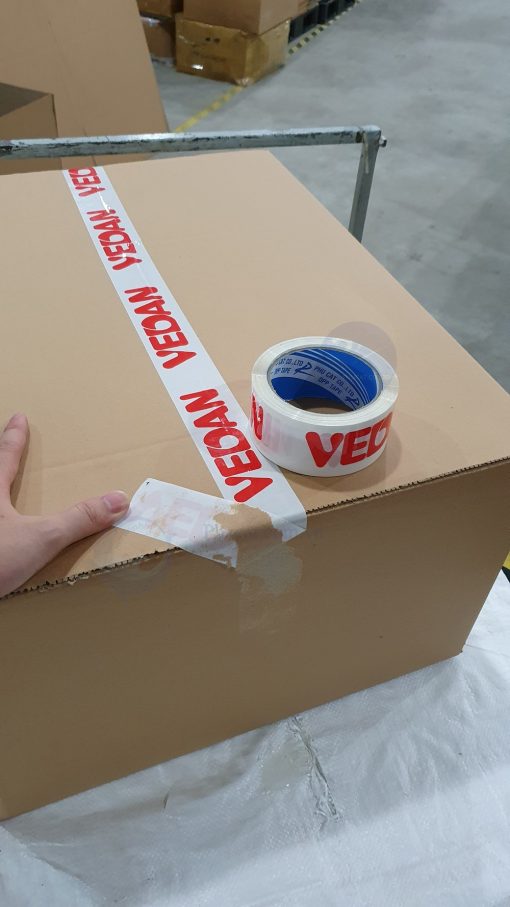 băng dính in logo đỏ nền trắng sứ khi dán trên thùng carton (1)